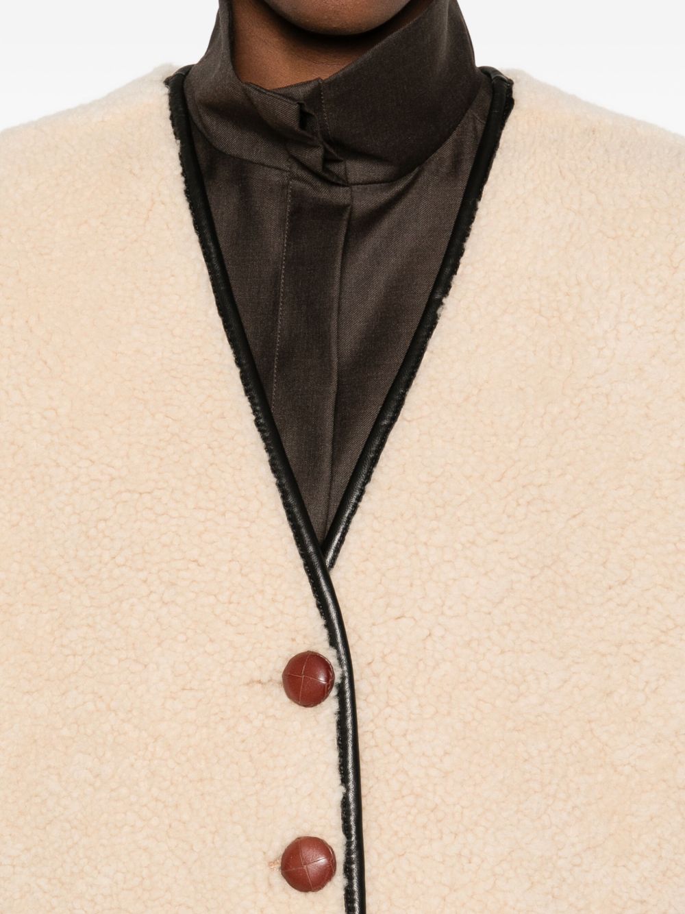 Gilet in shearling con profili in pelle in beige 