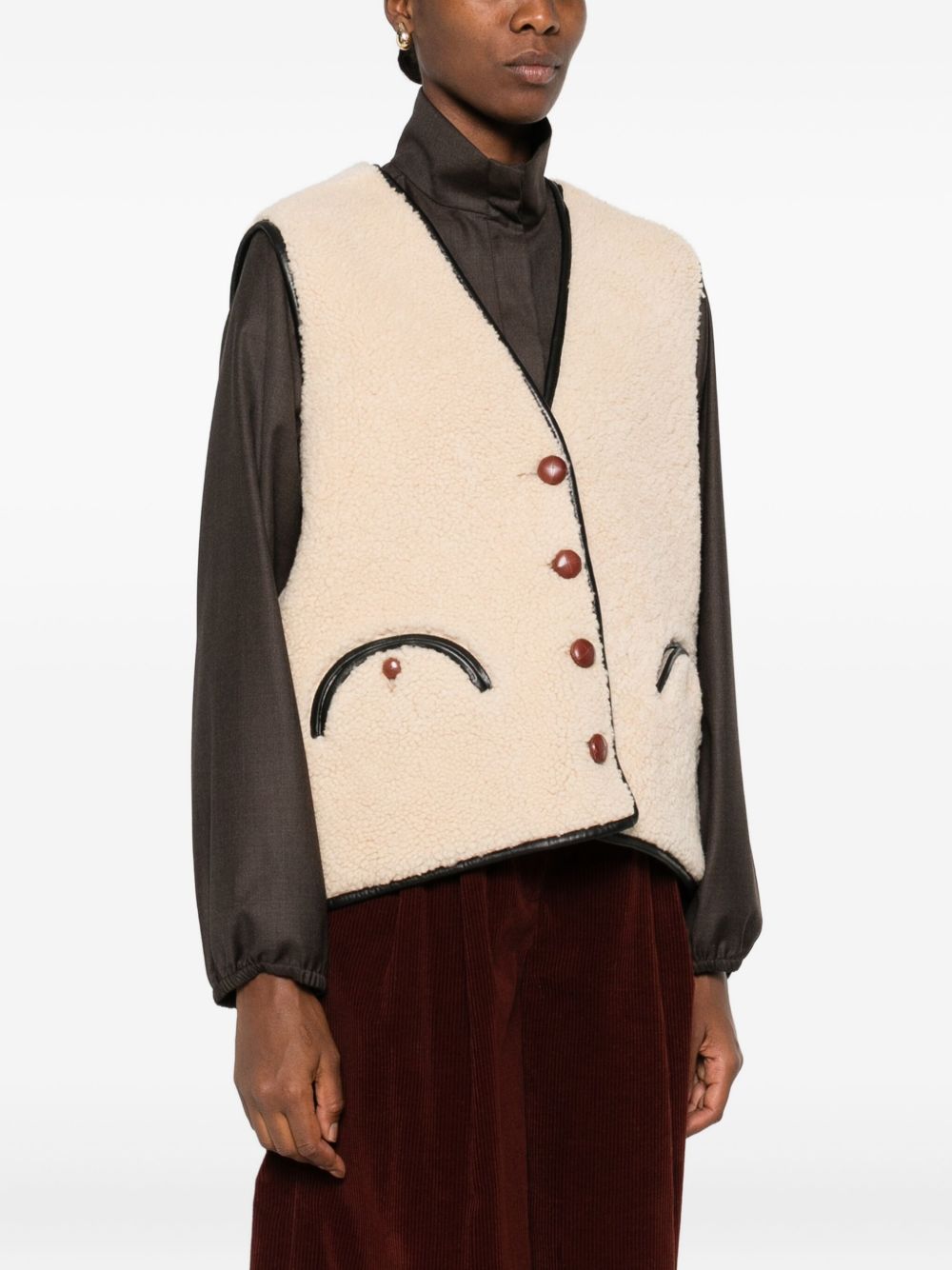 Gilet in shearling con profili in pelle in beige 