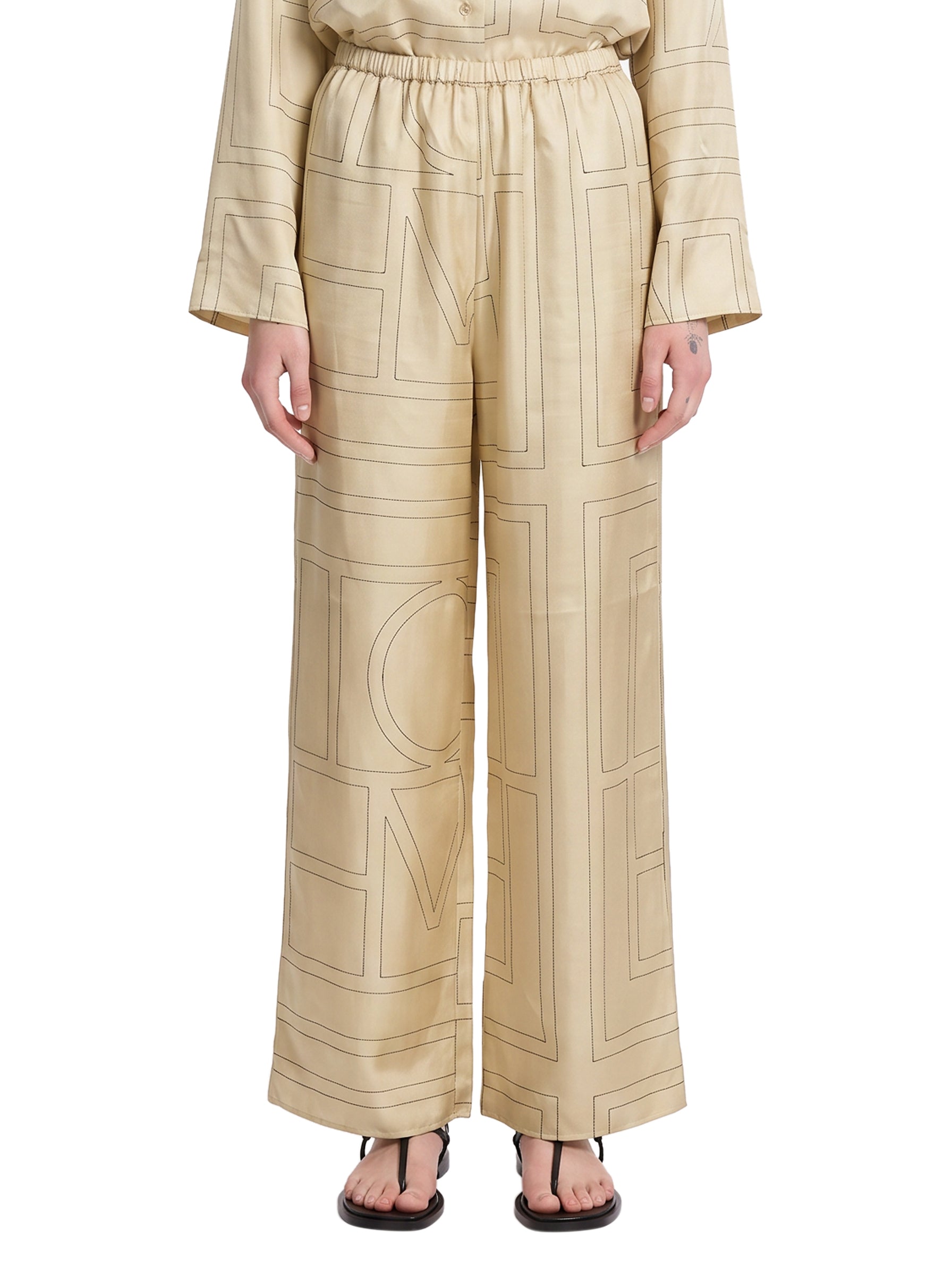 Pantaloni in seta con stampa monogramma in beige 