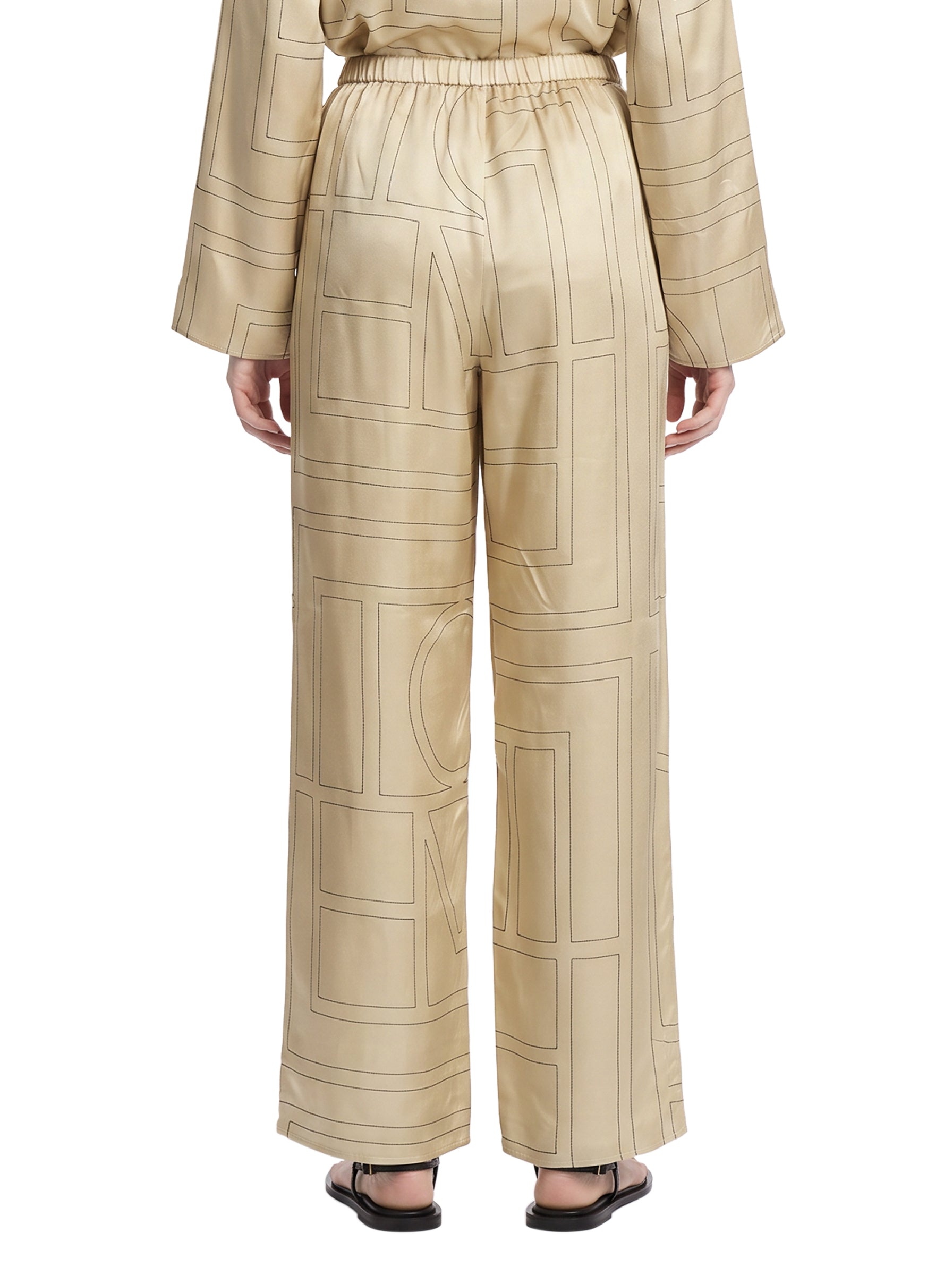 Pantaloni in seta con stampa monogramma in beige 