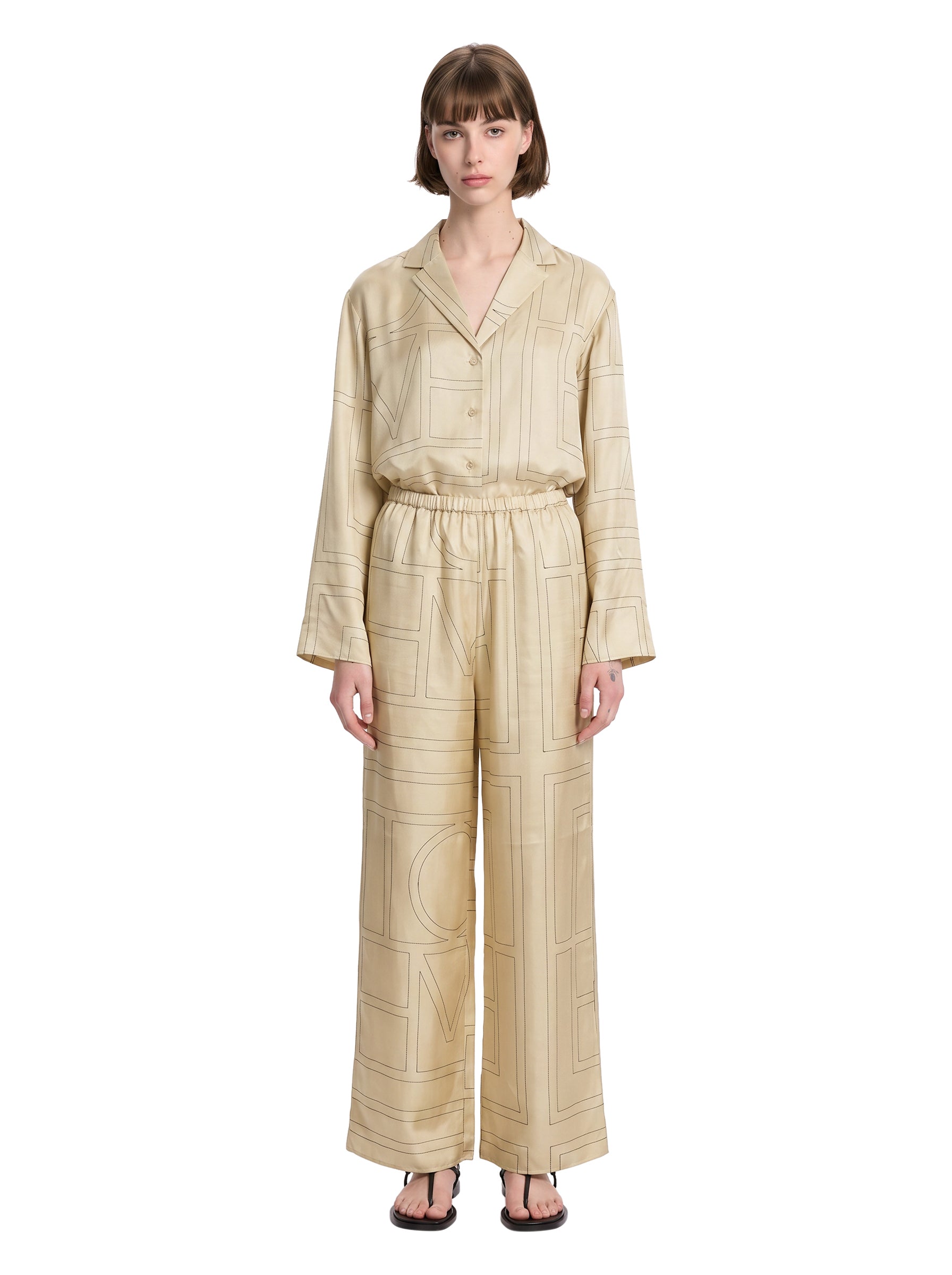 Pantaloni in seta con stampa monogramma in beige 