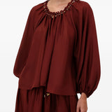 Blusa con decorazioni di perline Aster in bordeaux 