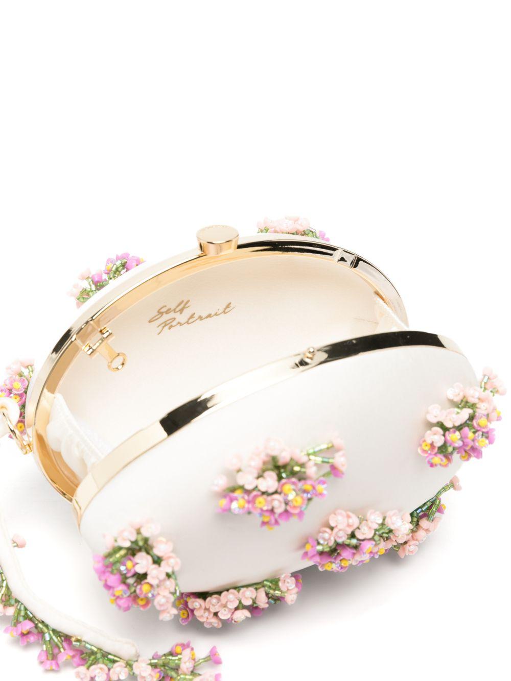 Clutch ovale con fiori in crema 