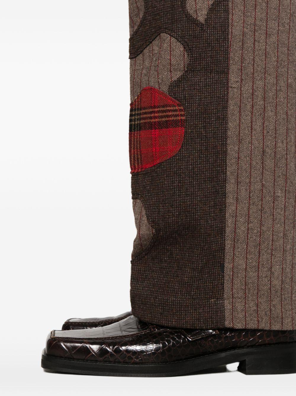 Pantaloni a righe con design patchwork  in marrone Kidsuper - uomo 