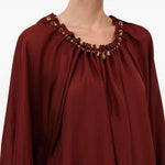 Blusa con decorazioni di perline Aster in bordeaux 