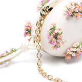 Clutch ovale con fiori in crema 